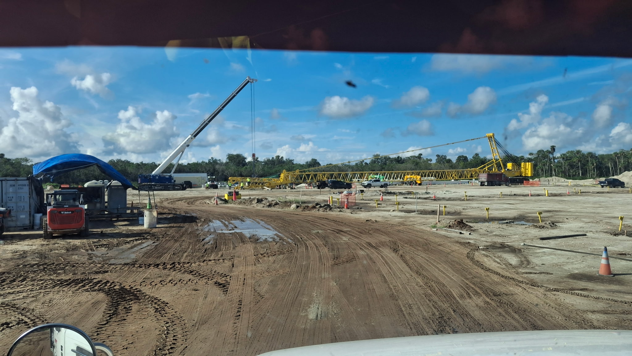 Graded construction pad with staged precast girders and an aggregate stockpile