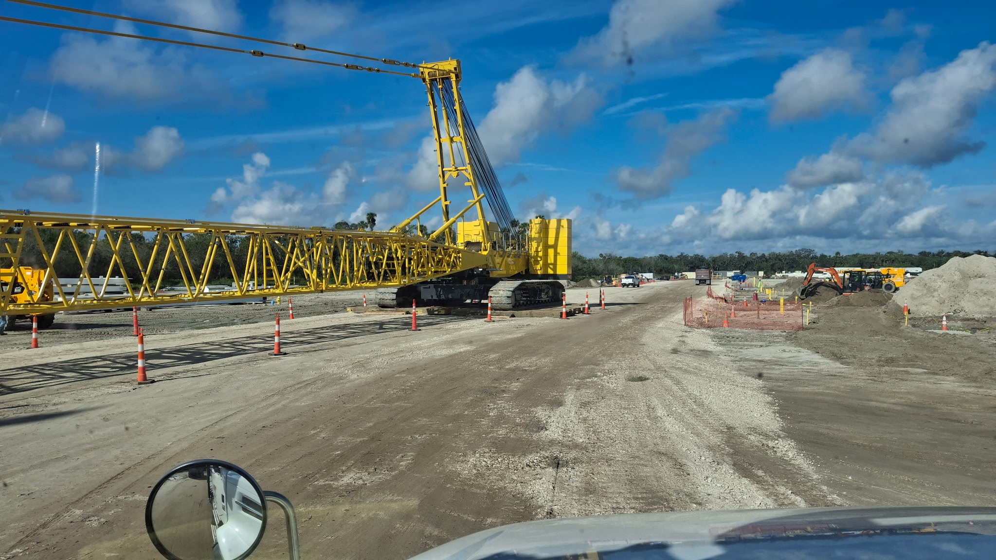 Heavy-civil jobsite with a crawler crane on a graded haul road