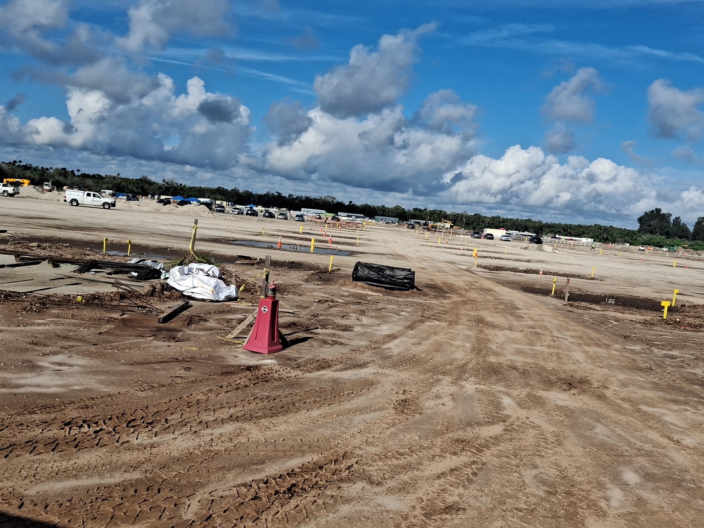 View from a truck cab across graded pads with cranes on site